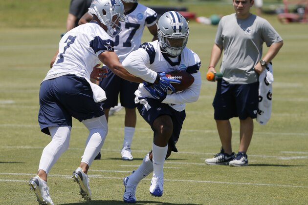 Dallas Cowboys quarterback Jameill Showers hands the ball off to running back Ezekiel Elliott during the team's NFL football minicamp, Saturday May 7, 2016, in Irving, Texas. (AP Photo/Tony Gutierrez)