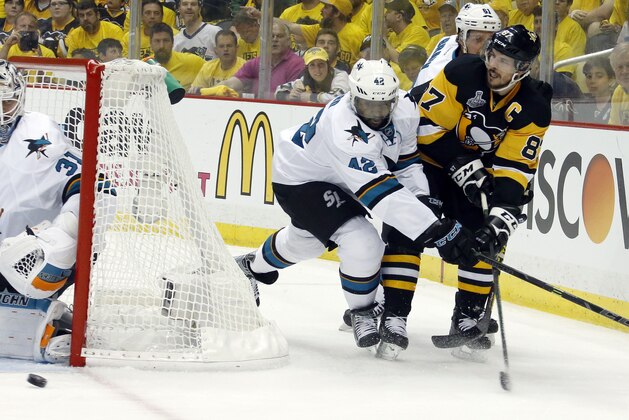Pittsburgh Penguins' Sidney Crosby, right, centers the puck past San Jose Sharks' Joel Ward (42) as Sharks goalie Martin Jones (31), defends during the first period in Game 1 of the Stanley Cup final series Monday, May 30, 2016, in Pittsburgh. (AP Photo/Keith Srakocic)