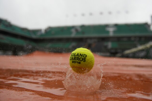 A picture taken on May 31, 2016 an official ball on the tarp covering the Philippe Chatrier central court as the rains falls over the Roland Garros stadium during the Roland Garros 2016 French Tennis Open in Paris on May 31, 2016. / AFP / MARTIN BUREAU        (Photo credit should read MARTIN BUREAU/AFP/Getty Images)