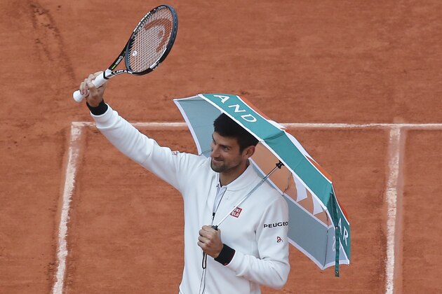 Serbia's Novak Djokovic walks onto center court with an umbrella before resuming his fourth round match of the French Open tennis tournament against Spain’s Roberto Bautista Agut at the Roland Garros stadium in Paris, France, Tuesday, May 31, 2016. (AP Photo/Michel Euler)