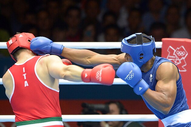 Roberto Cammarelle of Itay (in red) defends against Anthony Joshua of Great Britain (in blue) during the gold medal Super-Heavyweight (+91kg) boxing final of the 2012 London Olympic Games at the ExCel Arena August 12, 2012 in London.  AFP PHOTO / DAMIEN MEYER        (Photo credit should read DAMIEN MEYER/AFP/GettyImages)