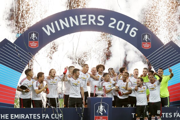 The Manchester United team celebrate with the trophy after winning the English FA Cup final soccer match against Crystal Palace at Wembley Stadium, London on Saturday May 21, 2016. Manchester United won the match 1-2. (AP Photo/Tim Ireland)