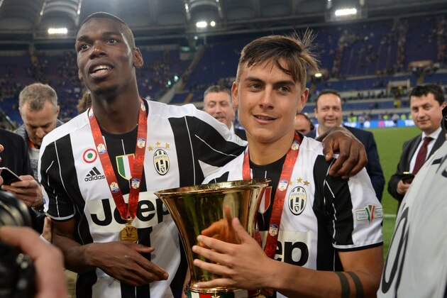 Juventus' forward from Argentina Paulo Dybala (R) and Juventus' midfielder from France Paul Pogba celebrate with the trophy after winning the Italian Tim Cup final football match AC Milan vs Juventus on May 21, 2016 at the Olympic Stadium in Rome.  Juventus won 0-1 in the extra time.    AFP PHOTO / FILIPPO MONTEFORTE / AFP / FILIPPO MONTEFORTE        (Photo credit should read FILIPPO MONTEFORTE/AFP/Getty Images)