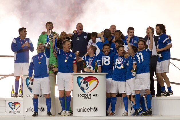 Players representing a Rest of the World team celebrate after their 4-2 win against an England team during the Soccer Aid 2014 charity soccer match at Old Trafford Stadium, Manchester, England, Sunday June 8, 2014. (AP Photo/Jon Super)