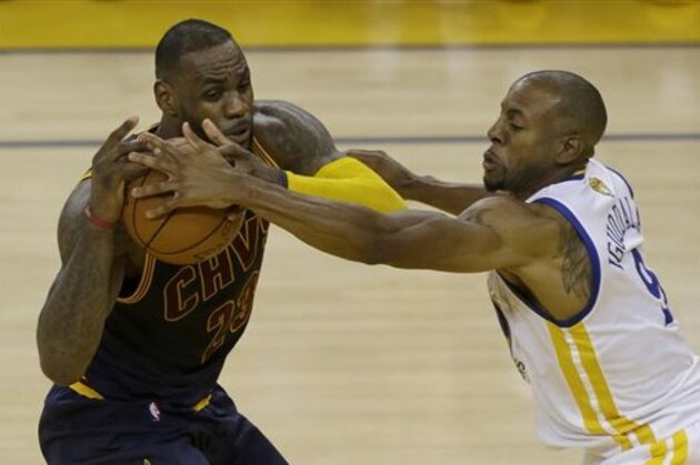Golden State Warriors forward Andre Iguodala, right, reaches for the ball against Cleveland Cavaliers forward LeBron James during the first half of Game 1 of basketball's NBA Finals in Oakland, Calif., Thursday, June 2, 2016. (AP Photo/Ben Margot)