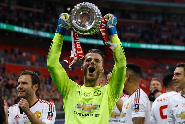 United’s goalkeeper David de Gea holds the trophy after they won the English FA Cup final soccer match between Manchester United and Crystal Palace at Wembley stadium in London, Saturday, May 21, 2016. United won 2-1. (AP Photo/Kirsty Wigglesworth)