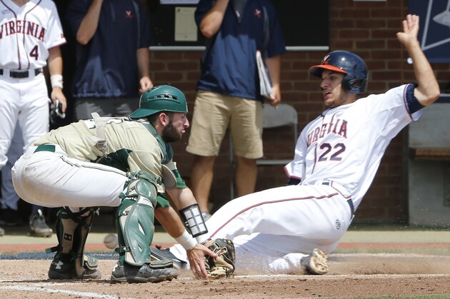 The ball slips through the glove of William & Mary catcher Hunter Smith (21) as Virginia infielder Daniel Pinero (22) scores a run in the second inning of an NCAA regional baseball game in Charlottesville, Va., Friday, June 3, 2016. (AP Photo/Steve Helber)