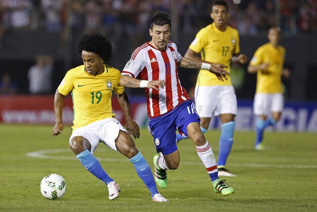 Brazil's Willian, left, fights for the ball with Paraguay's Edgar Benitez during a 2018 World Cup qualifying match against Brazil in Asuncion, Paraguay, Tuesday, March 28, 2016. (AP Photo/Cesar Olmedo)