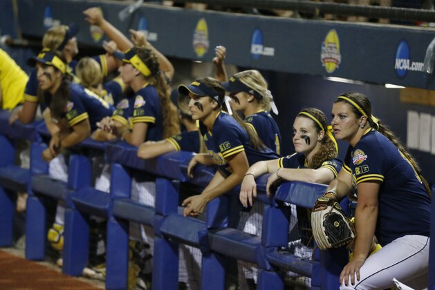 Michigan's Haylie Wagner, right, and other players watch from the dugout in the seventh inning of the final game against Florida in the NCAA softball Women's College World Series, Wednesday, June 3, 2015, in Oklahoma City. Florida won 4-1. (AP Photo/Sue Ogrocki)