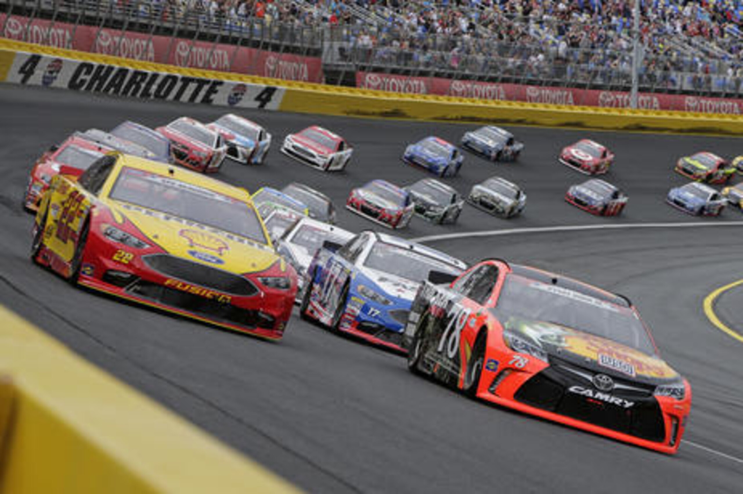 Martin Truex Jr (78) and Joey Logano (22) lead the field out of Turn 4 for the start of the NASCAR Sprint Cup series auto race at Charlotte Motor Speedway in Concord, N.C., Sunday, May 29, 2016. (AP Photo/Chuck Burton)