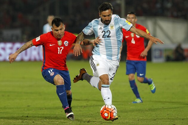Chile's Gary Medel (L) and Argentina's Ezequiel Lavezzi vie for the ball during their Russia 2018 FIFA World Cup South American Qualifiers' football match, in Santiago on March 24, 2016.  AFP PHOTO / CLAUDIO REYES / AFP / Claudio Reyes        (Photo credit should read CLAUDIO REYES/AFP/Getty Images)