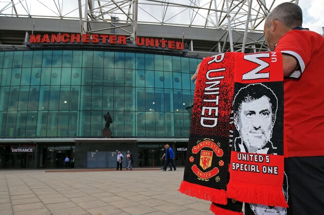 Scarves featuring the image of Manchester United's new Portuguese manager Jose Mourinho are displayed for sale outside the club's Old Trafford football stadium in Manchester, north-west England on May 27, 2016.
Manchester United on Friday anointed Jose Mourinho as their new manager to launch a third bid in less than three years to transform the Red Devils into a title-winning force again. After three days of talks, Mourinho agreed a three-year contract on a bumper salary reportedly worth more than $20 million (19.5 million euros) a year. / AFP / Clint Hughes        (Photo credit should read CLINT HUGHES/AFP/Getty Images)