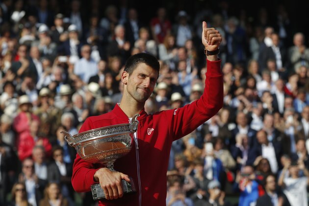Serbia's Novak Djokovic gives a thumbs up as he holds the trophy after winning the final of the French Open tennis tournament against Britain's Andy Murray in four sets 3-6, 6-1, 6-2, 6-4, at the Roland Garros stadium in Paris, France, Sunday, June 5, 2016. (AP Photo/Michel Euler)
