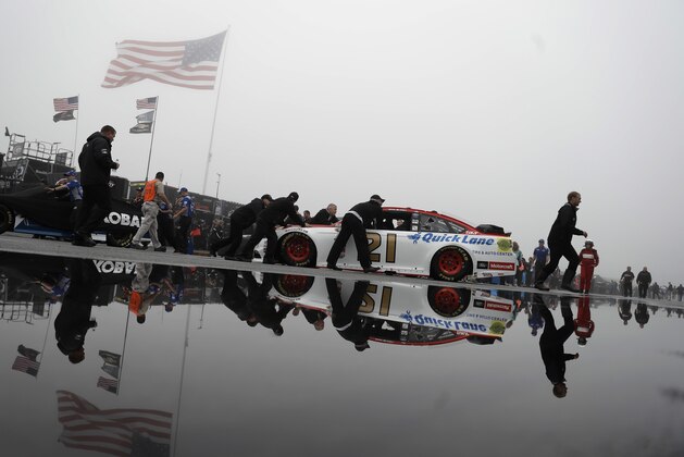 Crew members push the car of Ryan Blaney to the garage before the NASCAR Sprint Cup series auto race, Sunday, June 5, 2016, in Long Pond, Pa. (AP Photo/Matt Slocum)