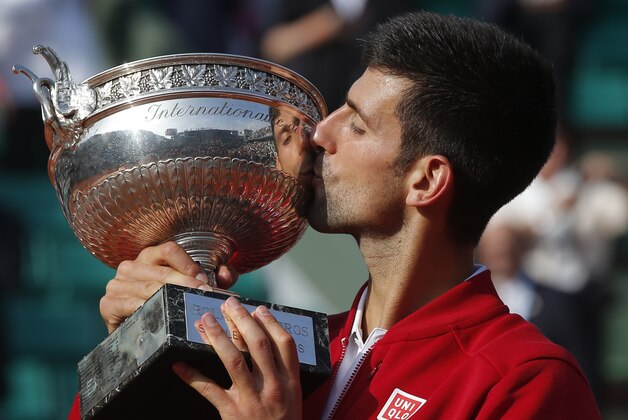Serbia's Novak Djokovic kisses the trophy after winning the final of the French Open tennis tournament against Britain's Andy Murray in four sets 3-6, 6-1, 6-2, 6-4, at the Roland Garros stadium in Paris, France, Sunday, June 5, 2016. (AP Photo/Michel Euler)