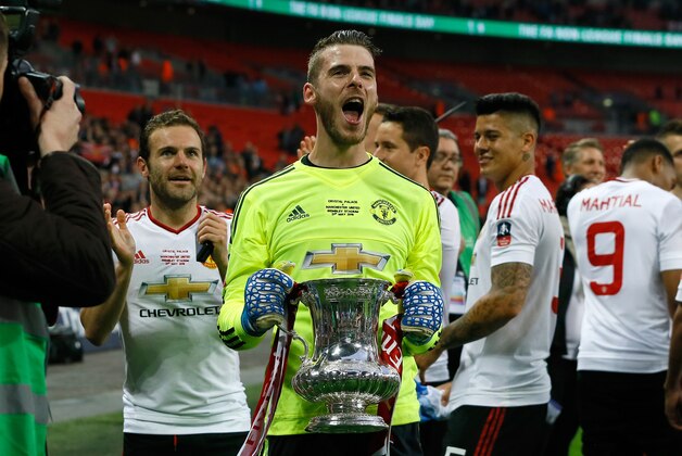 United’s goalkeeper David de Gea holds the trophy after they won the English FA Cup final soccer match between Manchester United and Crystal Palace at Wembley stadium in London, Saturday, May 21, 2016. United won 2-1. (AP Photo/Kirsty Wigglesworth)