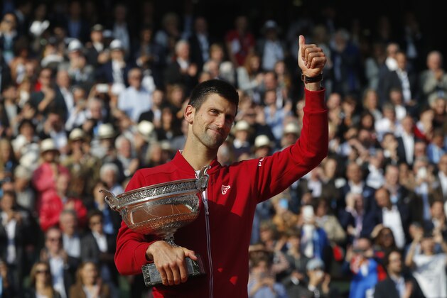 Serbia's Novak Djokovic gives a thumbs up as he holds the trophy after winning the final of the French Open tennis tournament against Britain's Andy Murray in four sets 3-6, 6-1, 6-2, 6-4, at the Roland Garros stadium in Paris, France, Sunday, June 5, 2016. (AP Photo/Michel Euler)