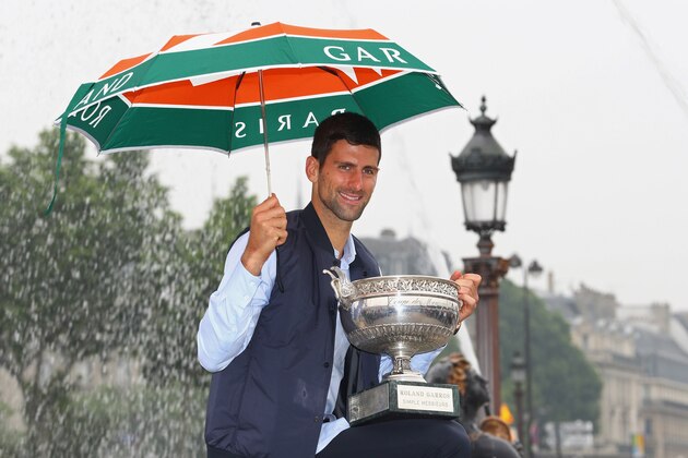 PARIS, FRANCE - JUNE 06:  Novak Djokovic of Serbia poses with the winners trophy whilst holding an umbrella at Place de La Concorde on June 6, 2016 in Paris, France.  (Photo by Julian Finney/Getty Images)