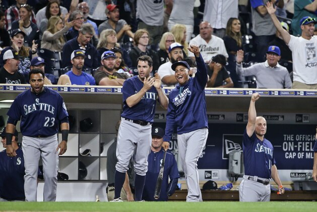 Seattle Mariners, including Nelson Cruz,  Seth Smith and Leonys Martin, from left, and fans celebrate as the Mariners score nine runs against the San Diego Padres in the seventh inning of a baseball game  Thursday, June 2, 2016, in San Diego. (AP Photo/Lenny Ignelzi)
