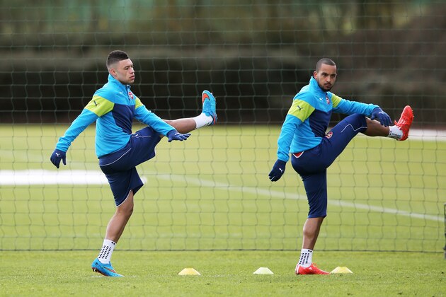 ST ALBANS, ENGLAND - FEBRUARY 24:  (L-R) Alex Oxlade-Chamberlain of Arsenal and Theo Walcott of Arsenal warm up during the Arsenal training session ahead of the UEFA Champions League round of 16 match against AS Monaco at London Colney on February 24, 2015 in St Albans, England.  (Photo by Clive Mason/Getty Images)