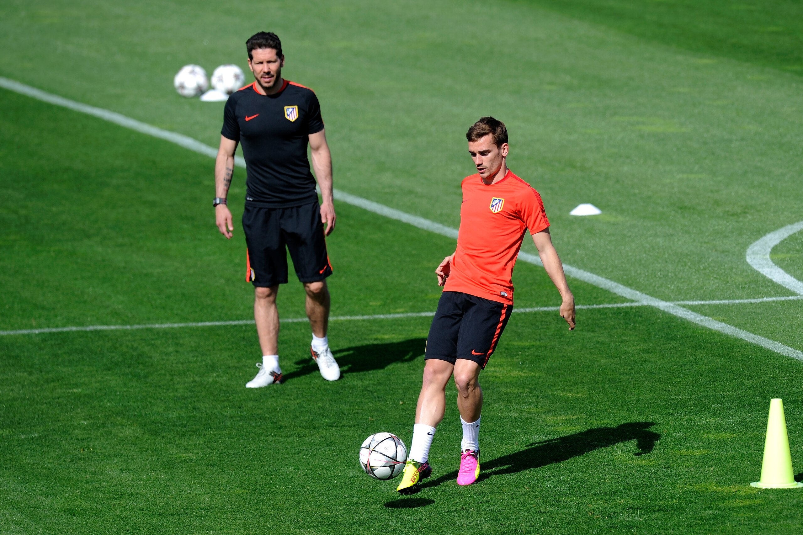MADRID, SPAIN - APRIL 26: Antoine Griezmann of Atletico Madrid passes the ball as Diego Simeone, Manager of Atletico Madrid watches during a training session ahead of the UEFA Champions League Semi-Final First Leg between Club Atletico de Madrid and Bayern Meunchen at Majadahonda training ground on April 26, 2016 in Madrid, Spain. (Photo by Denis Doyle/Getty Images) MADRID, SPAIN - APRIL 26: Antoine Griezmann of Atletico Madrid passes the ball as Diego Simeone, Manager of Atletico Madrid watches during a training session ahead of the UEFA Champions League Semi-Final First Leg between Club Atletico de Madrid and Bayern Meunchen at Majadahonda training ground on April 26, 2016 in Madrid, Spain. (Photo by Denis Doyle/Getty Images)