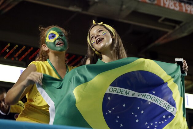 Brazilian soccer fans wave a flag before an international friendly soccer match between Brazil and Colombia, Friday, Sept. 5, 2014, in Miami Gardens, Fla. (AP Photo/Lynne Sladky)