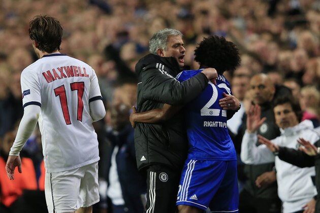 Chelsea's Portuguese manager Jose Mourinho (C) embraces Chelsea's Brazilian midfielder Willian (R) on the touchline in the final minutes of the match during the UEFA Champions League quarter final second leg football match between Chelsea and Paris Saint-Germain at Stamford Bridge in London on April 8, 2014. Chelsea won 2-0 going through to the semi-final on the away goals rule. AFP PHOTO / ADRIAN DENNIS        (Photo credit should read ADRIAN DENNIS/AFP/Getty Images)