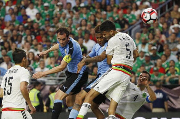 Uruguay's Diego Godin, second from left, heads the ball to the goal for a score, sending it past Mexico's Diego Reyes (5), Rafael Marquez (4) and teammate Abel Hernandez as Mexico's Hector Moreno (15) looks on during the second half of a Copa America group C soccer match at University of Phoenix Stadium Sunday, June 5, 2016, in Glendale, Ariz. Mexico defeated Uruguay 3-1. (AP Photo/Ross D. Franklin)