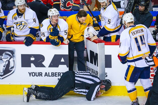 Jan 27, 2016; Calgary, Alberta, CAN; NHL linesman Don Henderson (91) after he was cross-checked by Calgary Flames defenseman Dennis Wideman (6) during the second period between the Calgary Flames and the Nashville Predators at Scotiabank Saddledome. Nashville Predators won 2-1. Mandatory Credit: Sergei Belski-USA TODAY Sports