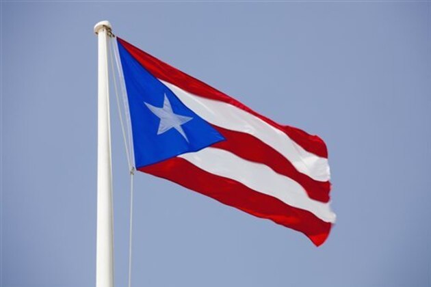 Morro Castle, Puerto Rican flags flying against blue sky (Photo by: Tetra Images/AP Images)