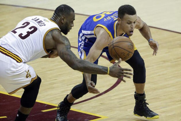 Cleveland Cavaliers forward LeBron James (23) and Golden State Warriors guard Stephen Curry (30) reach for a loose ball during the second half of Game 3 of basketball's NBA Finals in Cleveland, Wednesday, June 8, 2016. (AP Photo/Tony Dejak)