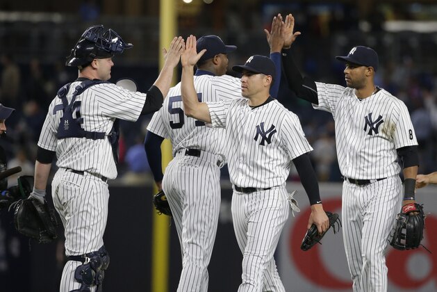 New York Yankees catcher Brian McCann (34) and relief pitcher Aroldis Chapman (54) celebrate with Jacoby Ellsbury, and Aaron Hicks, right, after a baseball game against the Los Angeles Angels on Thursday, June 9, 2016, in New York. The Yankees won 6-3. (AP Photo/Frank Franklin II)