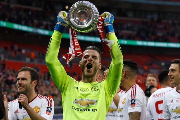 United’s goalkeeper David de Gea holds the trophy after they won the English FA Cup final soccer match between Manchester United and Crystal Palace at Wembley stadium in London, Saturday, May 21, 2016. United won 2-1. (AP Photo/Kirsty Wigglesworth)