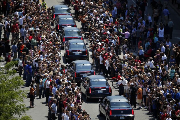 Muhammad Ali's funeral procession passes as onlookers line the street Friday, June 10, 2016, in Louisville, Ky. (AP Photo/Jeff Roberson)