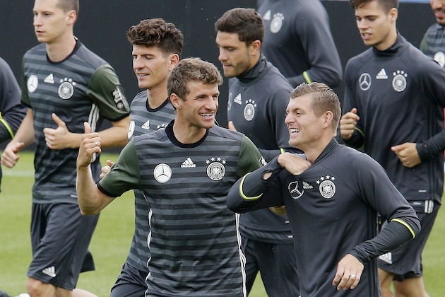 Thomas Mueller, center, and Toni Kroos, right, chat as they run during a training session of the German national soccer team in the Camille Fournier stadium at their base camp in Evian, France, Thursday, June 9, 2016. Germany will face the Ukraine in a Euro 2016 Group C soccer match in Lille on Sunday, June, 12, 2016. (AP Photo/Michael Probst)