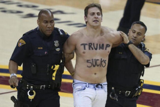 Cleveland police officers escort a fan who ran onto the court during the second half of Game 4 of basketball's NBA Finals between the Cleveland Cavaliers and Golden State Warriors in Cleveland, Friday, June 10, 2016. (AP Photo/Ron Schwane)