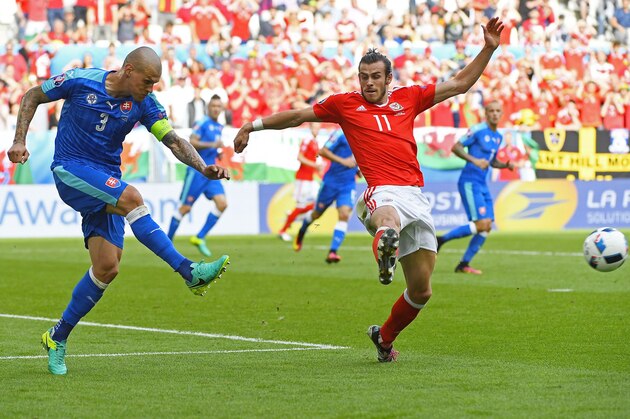 Slovakia's defender Martin Skrtel (L) kicks the ball past Wales' forward Gareth Bale during the Euro 2016 group B football match between Wales and Slovakia at the Stade de Bordeaux in Bordeaux on June 11, 2016. / AFP / Joe KLAMAR        (Photo credit should read JOE KLAMAR/AFP/Getty Images)