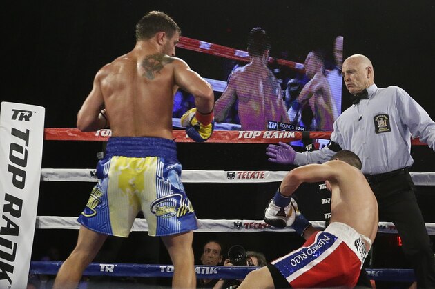 Vasyl Lomachenko, left, of Ukraine, knocks down Roman Martinez, of Puerto Rico, during the fifth round of a WBO junior lightweight title boxing match Saturday, June 11, 2016, in New York. Lomachenko stopped Martinez in the fifth round. (AP Photo/Frank Franklin II)