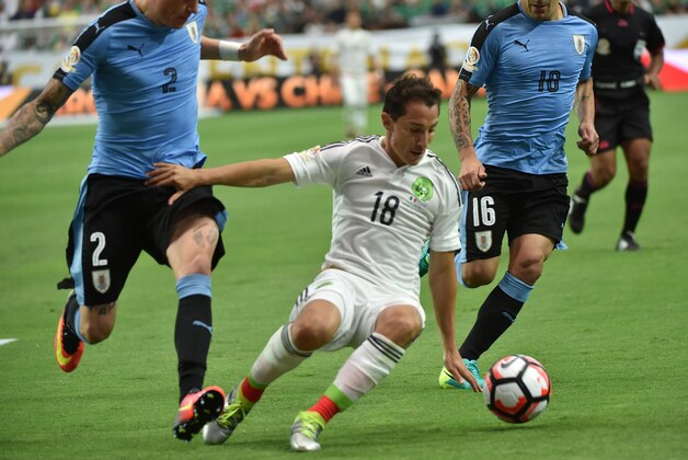 Mexico's Andres Guardado (C) is marked by Uruguay's Jose Maria Gimenez during their Copa America Centenario football tournament match in Glendale, Arizona, United States, on June 5, 2016.  / AFP / NELSON ALMEIDA        (Photo credit should read NELSON ALMEIDA/AFP/Getty Images)