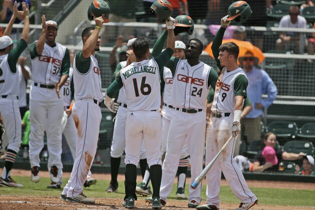 Miami's Edgar Michelangeli (16) is congratulated by teammates after hitting a home run scoring Willie Abreu and Jacob Heyward during the second inning of NCAA college baseball tournament super regional game against Boston College, Sunday, June 12, 2016, in Coral Gables, Fla. (AP Photo/Wilfredo Lee)