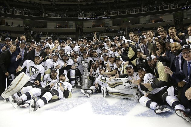 Pittsburgh Penguins players and coaches pose for photos with the Stanley Cup after Game 6 of the NHL hockey Stanley Cup Finals against the San Jose Sharks in San Jose, Calif., Sunday, June 12, 2016. The Penguins won 3-1 to win the series 4-2. (AP Photo/Marcio Jose Sanchez)