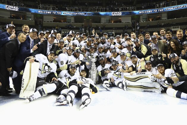 Pittsburgh Penguins players and coaches pose for photos with the Stanley Cup after Game 6 of the NHL hockey Stanley Cup Finals against the San Jose Sharks in San Jose, Calif., Sunday, June 12, 2016. The Penguins won 3-1 to win the series 4-2. (Bruce Bennett/Getty Images via AP, Pool)