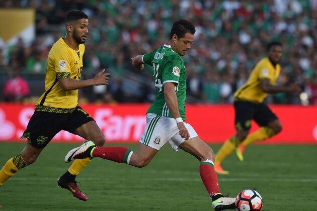 Jamaica's Joel McAnuff (L) and Mexico's Chicharito Hernandez (R) vie for the ball during the Copa America Centenario football match in Pasadena, California, United States, on June 9, 2016.  / AFP / Mark Ralston        (Photo credit should read MARK RALSTON/AFP/Getty Images)