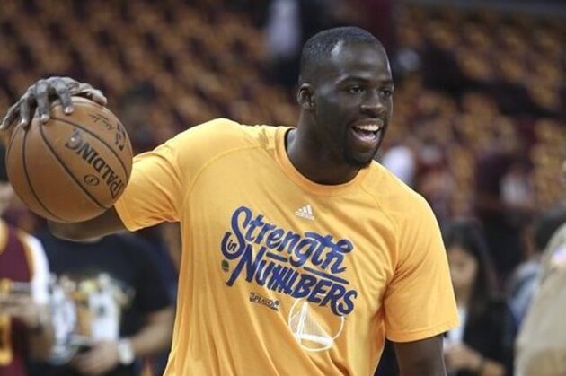 Golden State Warriors forward Draymond Green dribbles during warm ups before Game 4 of basketball's NBA Finals against the Cleveland Cavaliers in Cleveland, Friday, June 10, 2016. (AP Photo/Ron Schwane)