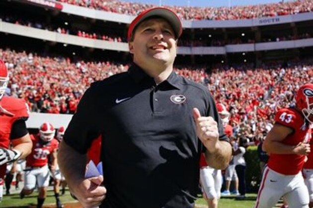 FILE - In this April 16, 2016 file photo, Georgia first-year head coach Kirby Smart runs into a packed Sandford Stadium with his players for the school's spring NCAA college football game in Athens, Ga. The Southeastern Conference Eastern Division’s new look added more intrigue than usual to spring practice. Three of the division’s seven teams - Georgia, Missouri and South Carolina - are breaking in new head coaches. (AP Photo/John Bazemore, File)
