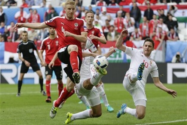 Austria's Martin Hinteregger, left, and  Hungary's Zoltan Gera, right, go for the ball during the Euro 2016 Group F soccer match between Austria and Hungary at the Nouveau Stade in Bordeaux, France, Tuesday, June 14, 2016. (AP Photo/Petr David Josek)