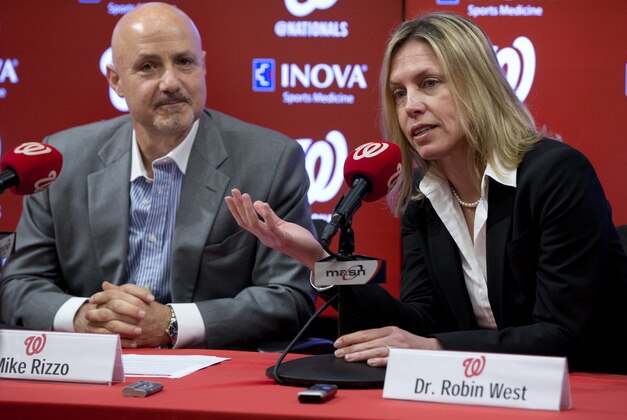 Washington Nationals Lead Team Physician Dr. Robin West, right,  joined by Washington Nationals general manager Mike Rizzo, speaks during a news conference at Nationals Park in Washington, Wednesday, Nov. 18, 2015, about the baseball team's new medical structure. The goal of expanding and restructuring their medical structure is to thwart potential injurious situations and increase performance by maintaining the health and wellness of players. (AP Photo/Carolyn Kaster)