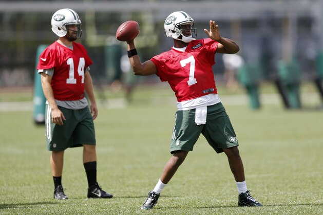 New York Jets Geno Smith, right, throws as quarterback Ryan Fitzpatrick looks on during organized team activities at the team's NFL football training center, Wednesday, June 3, 2015, in Florham Park, N.J. (AP Photo/Julio Cortez)