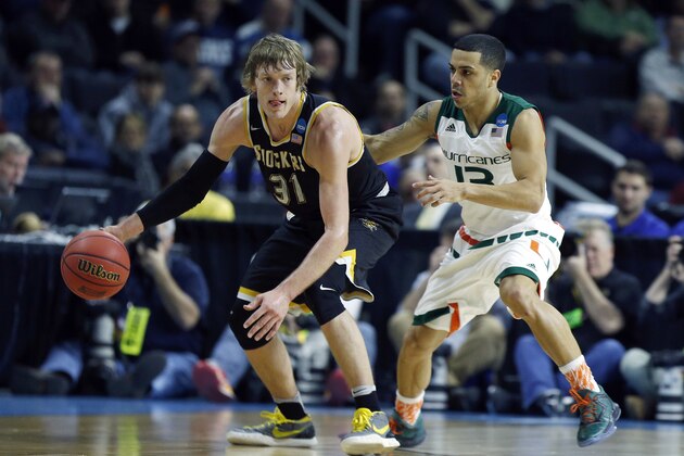 Miami's Angel Rodriguez (13) defends against Wichita State's Ron Baker (31) during the first half of a second round game in the NCAA men's college basketball tournament in Providence, R.I., Saturday, March 19, 2016. (AP Photo/Michael Dwyer)