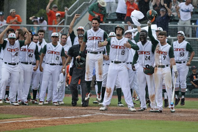 Miami players wait at home plate to celebrate after Edgar Michelangeli hit a grand slam in the seventh inning of NCAA college baseball tournament super regional game against Boston College, Sunday, June 12, 2016, in Coral Gables, Fla. (AP Photo/Wilfredo Lee)